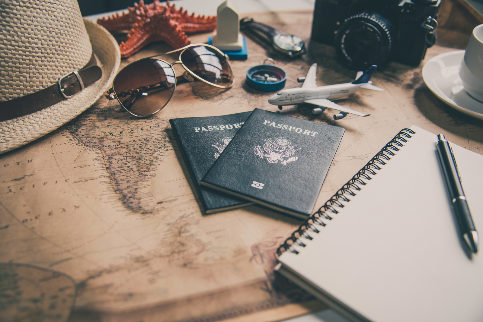 Passports and travel trinkets on a table. 