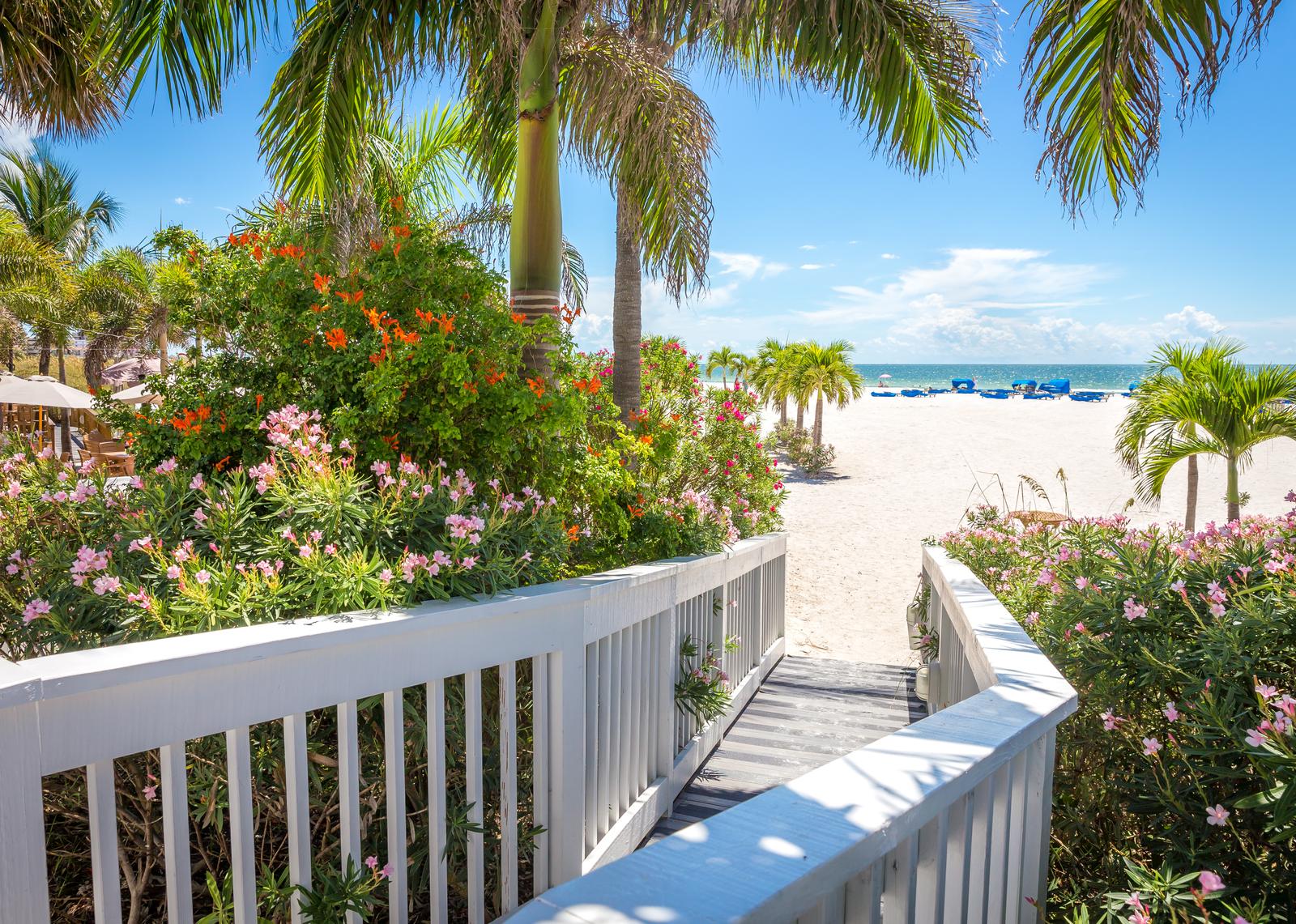 Walkway to the St. Pete Beach with tropical greenery and white sands on the Gulf Coast.