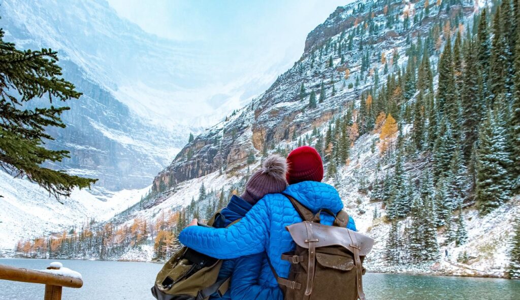 Lake Agnes Canada near Lake Louise Canada Alberta. Couple hiking in the forest with snow by Lake Louise Canada Alberta Canadian Rockies during winter.