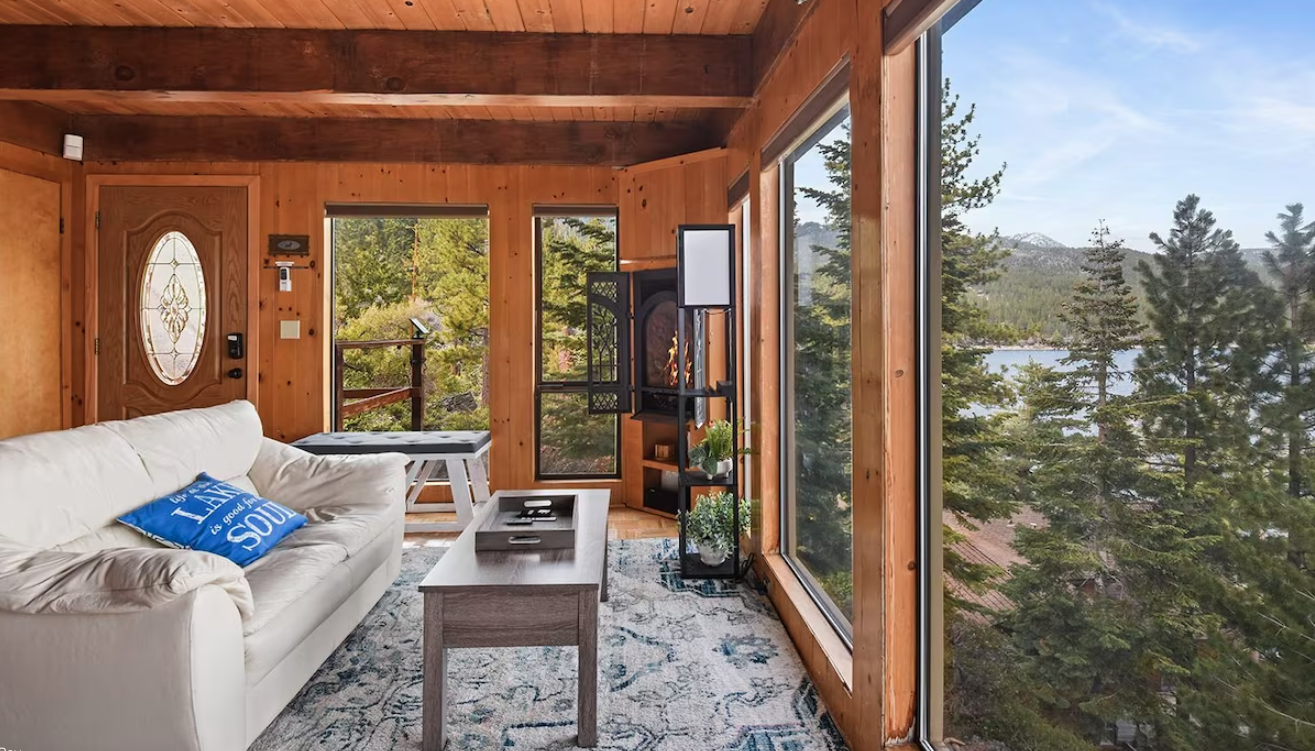 Guest room with floor to ceiling windows overlooking mountain view.