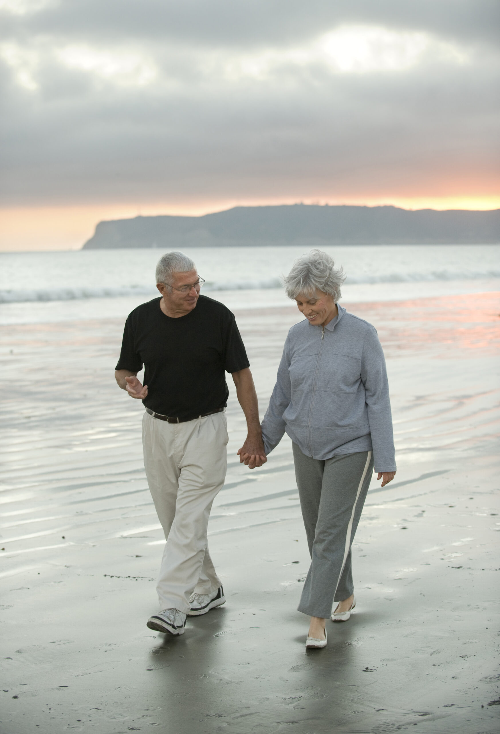 Senior couple enjoying a walk on a beach, one of the most romantic things to do in Southern California.