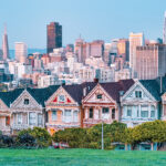 Painted ladies Victorian houses with city skyline in San Francisco.