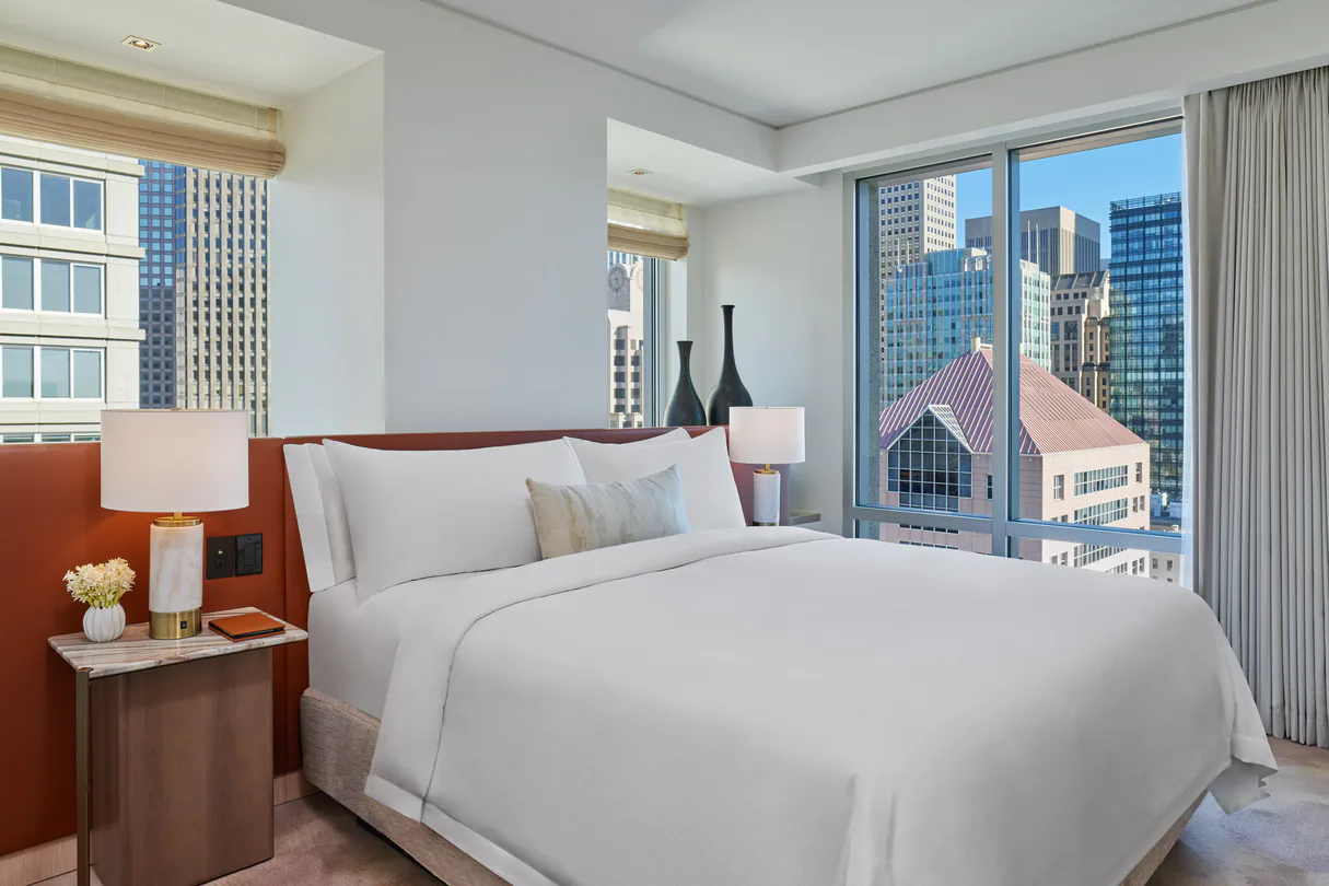 White king bed with big windows out-looking the city at St. Regis hotel in San Francisco. 