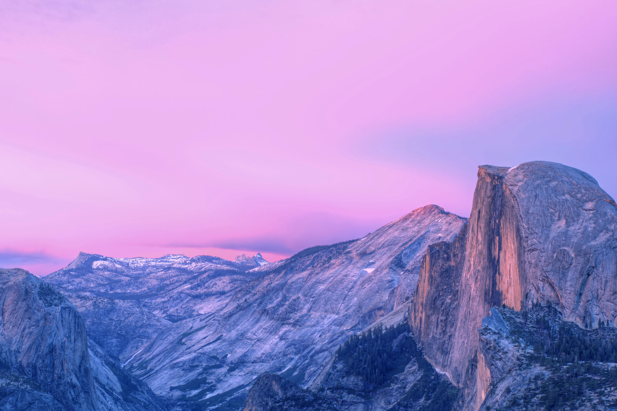 Yosemite National Park scenic view with pink hue in sky.