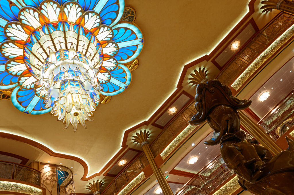 Main hall in Disney cruise ship. Atrium with Donald duck statue and colorful chandelier