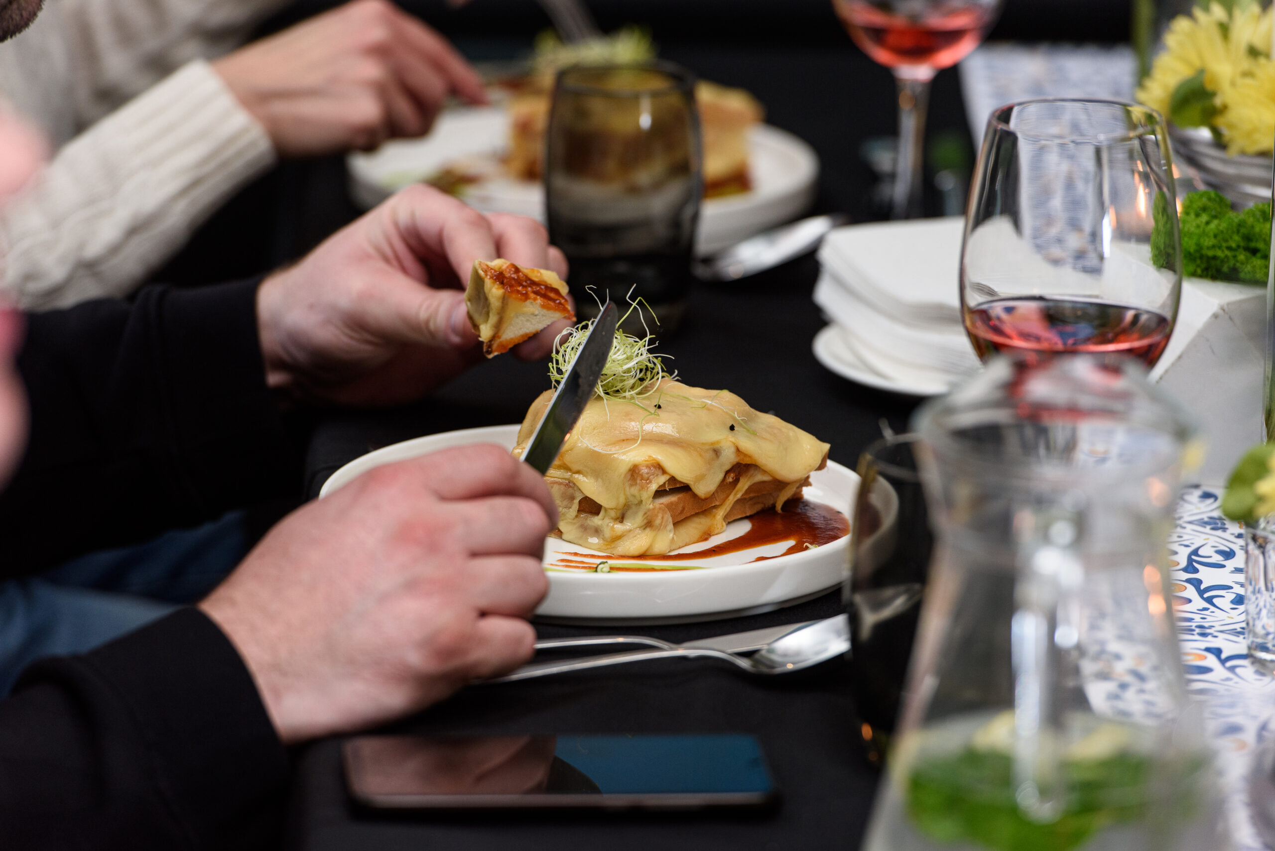 Man eating Francesinha, traditional Portuguese sandwich in a restaurant. It's one of the romantic things to do in Lisbon!