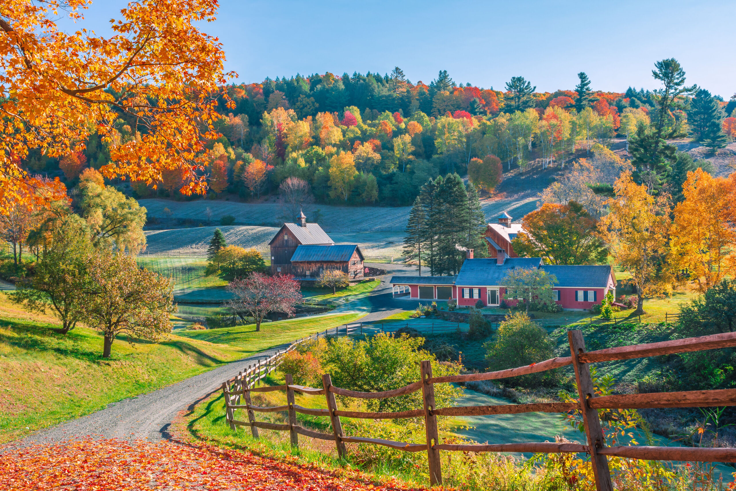 An early autumn foliage scene of houses in Woodstock, Vermont mountains. It's one of the most romantic fall getaways for couples!