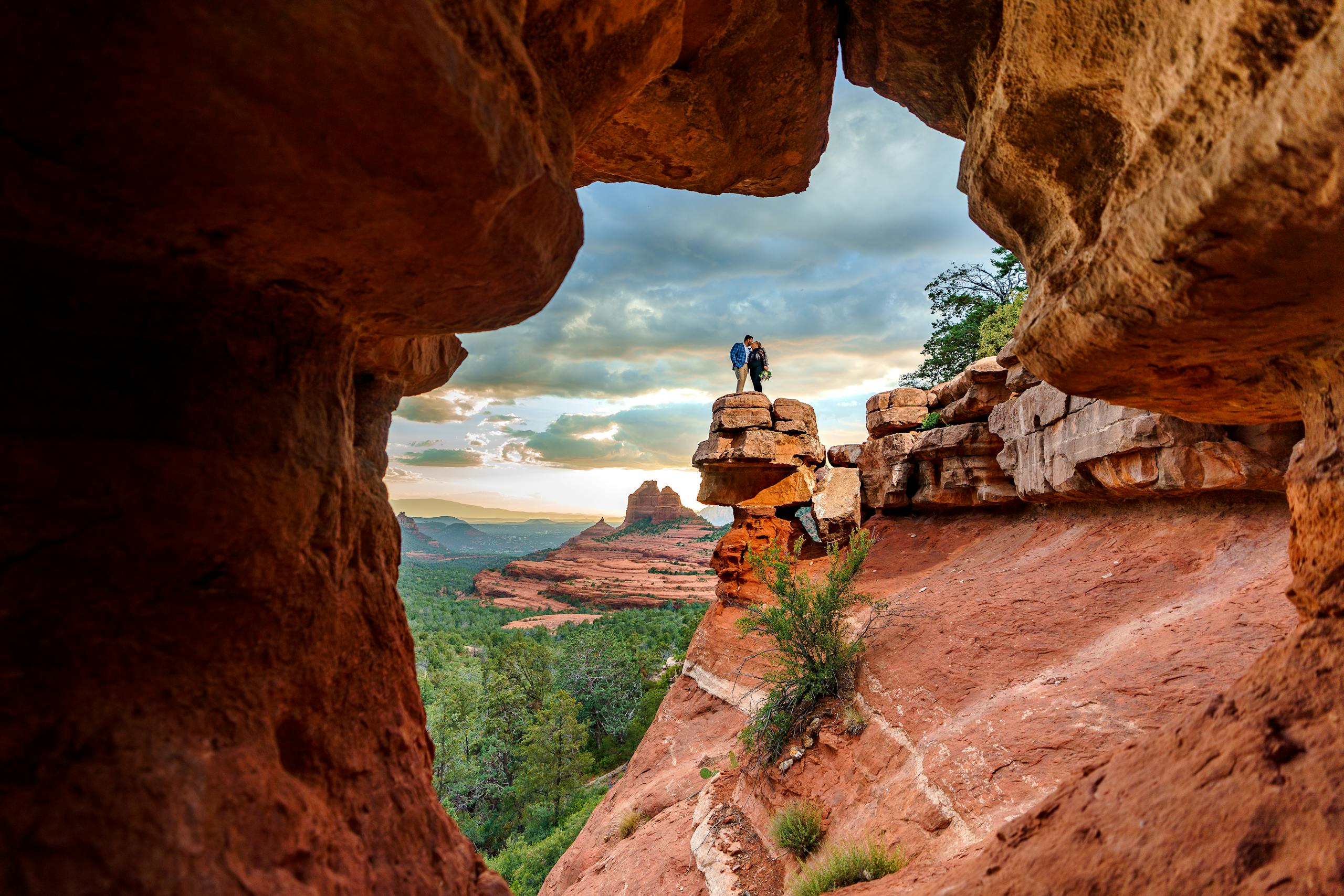 A couple embraces atop a red rock formation on a weekend in Sedona.