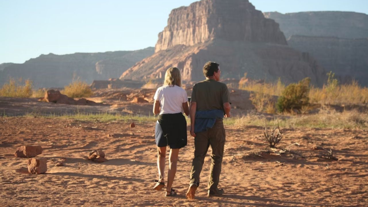 Couple walking through red rock desert landscape at Canyonlands National Park.