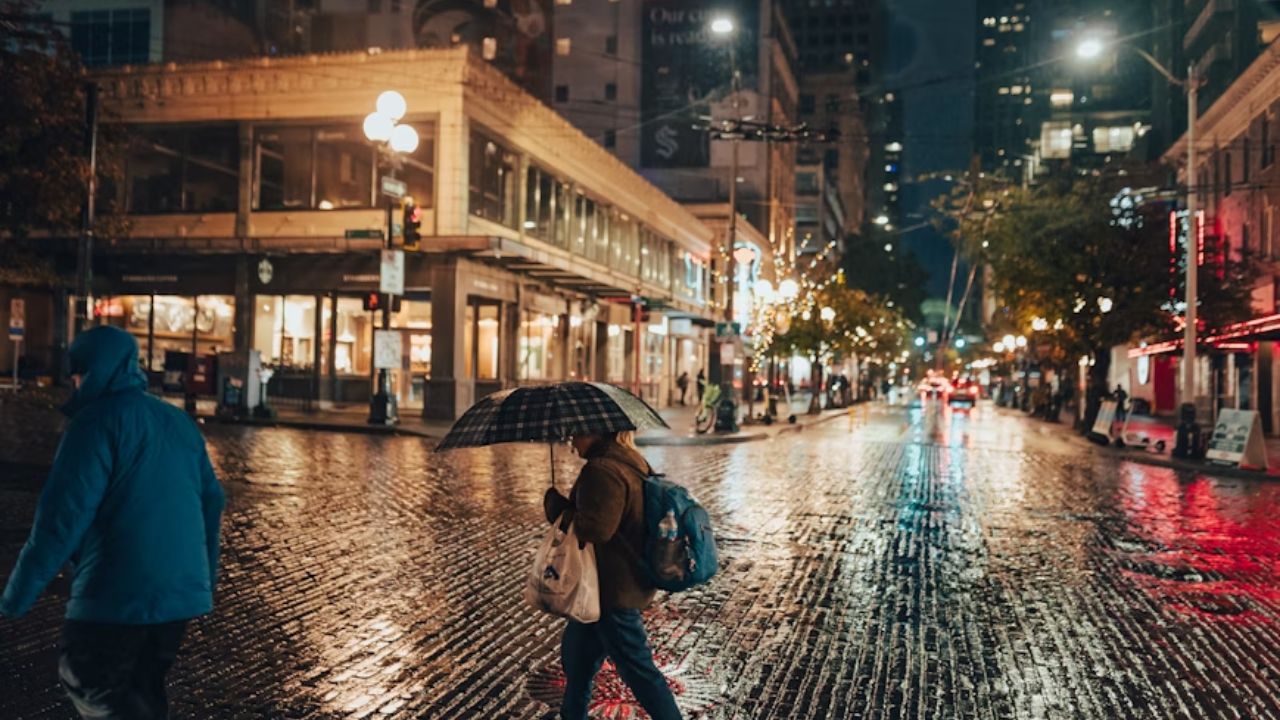 People walking with umbrellas on a rainy night in downtown Seattle, Washington.
