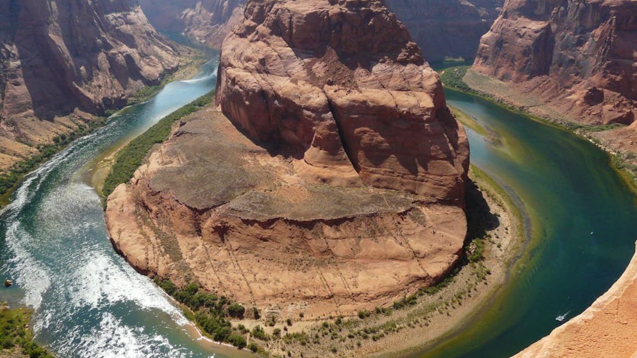Aerial view of Horseshoe Bend near Page, Arizona, where the Colorado River curves around a massive red rock formation in the desert landscape.