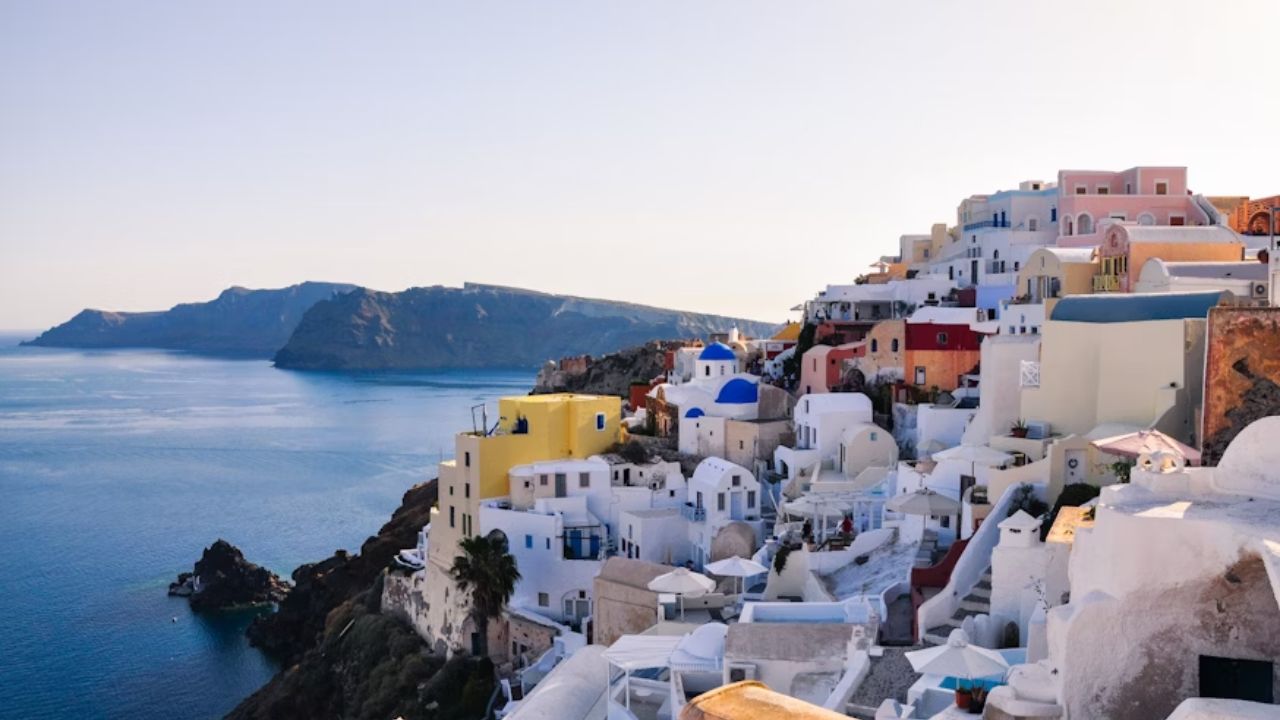 Colorful cliffside houses overlooking the Aegean Sea in Oia, Santorini, Greece.