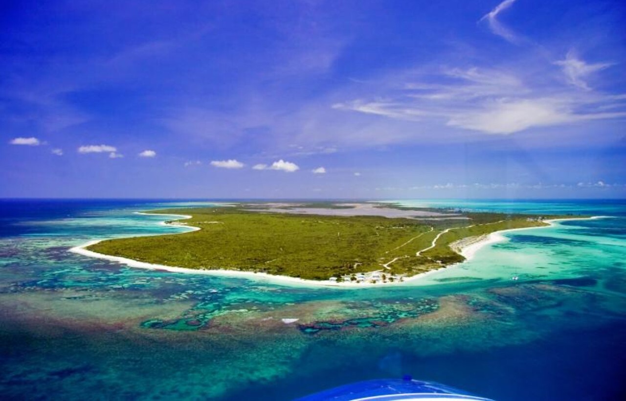 Aerial view of Anegada Island with turquoise reefs and white sand.