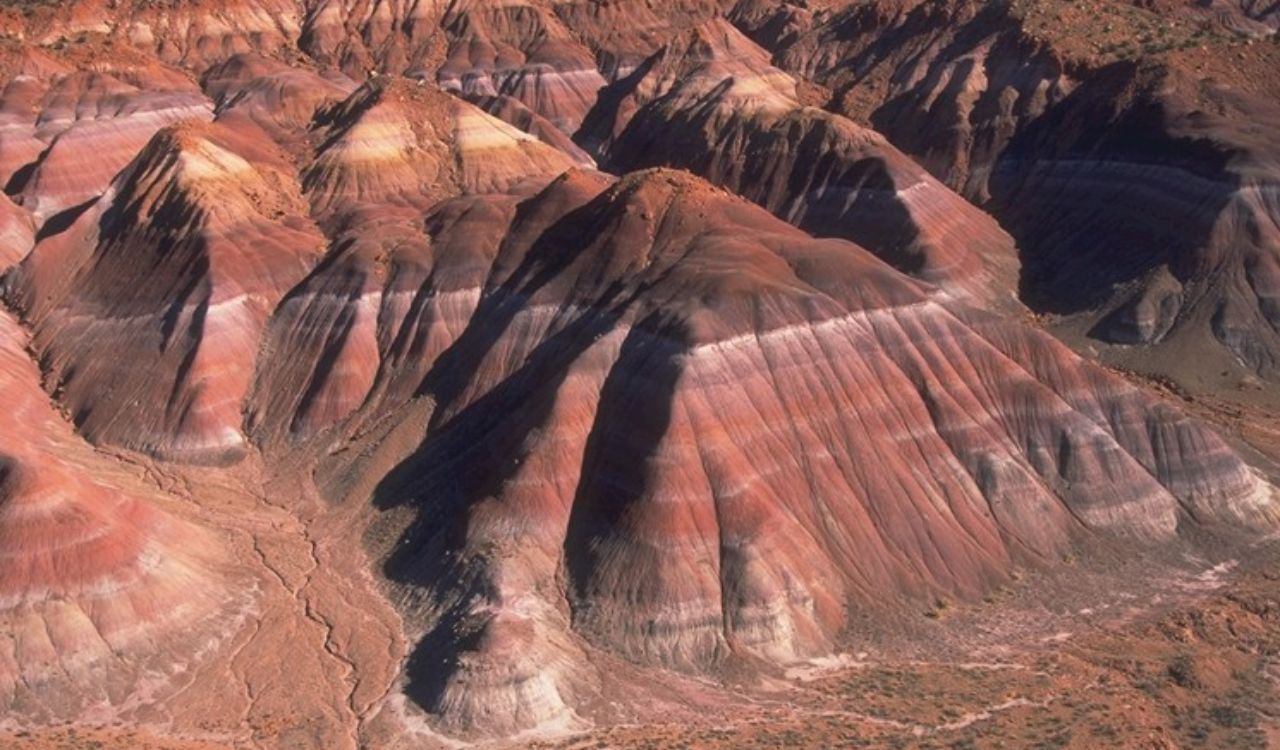 Colorful, eroded hills of Badlands National Park glow under sunlight