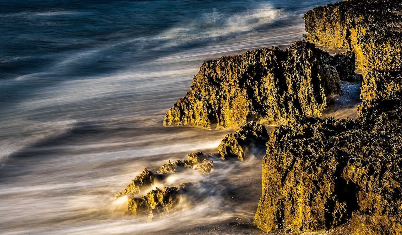 Waves crashing against jagged rocks at Blowing Rocks Preserve, Florida