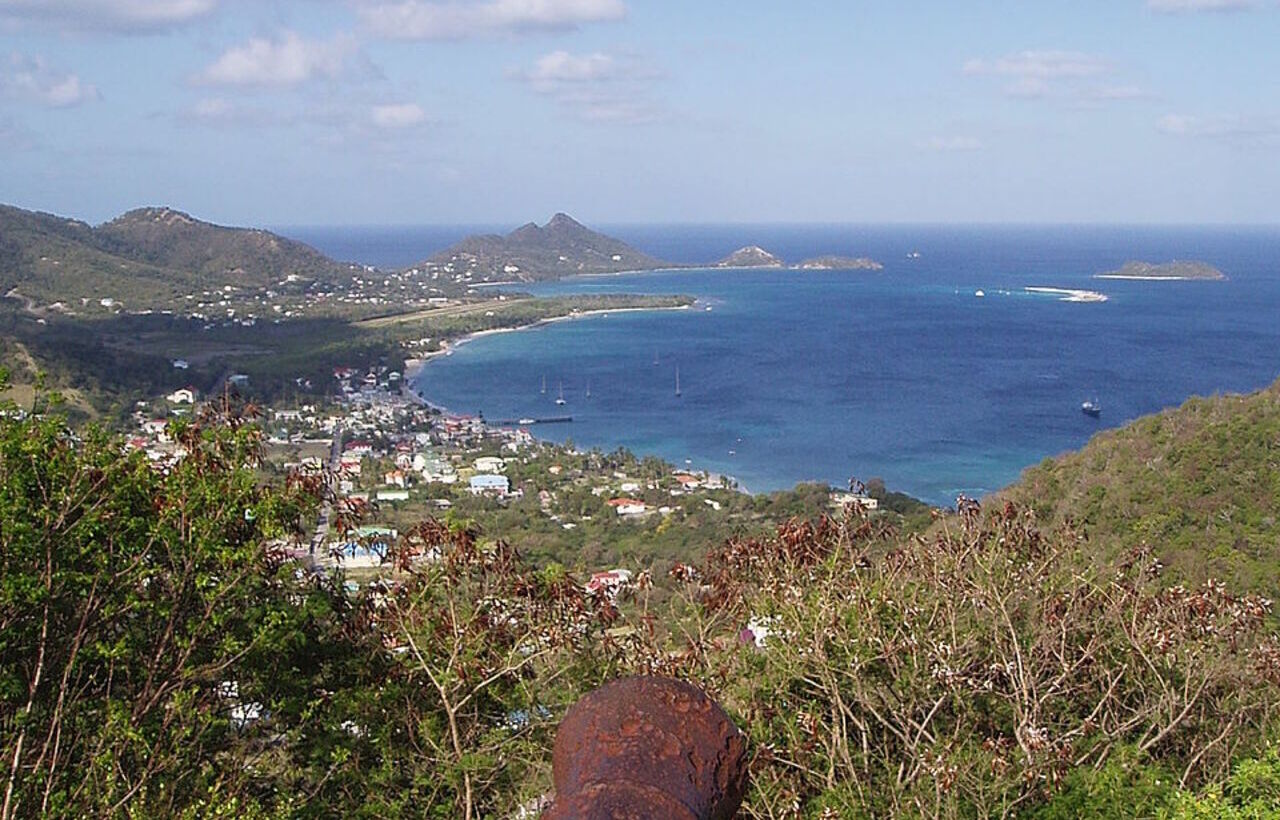 View of Carriacou, Grenada with coastal town and surrounding blue sea.