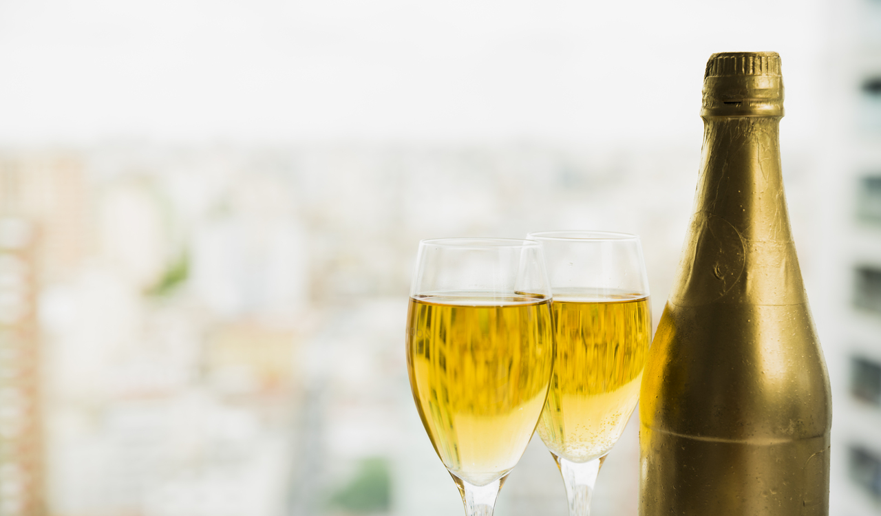 Glasses of drink near bottle of alcohol