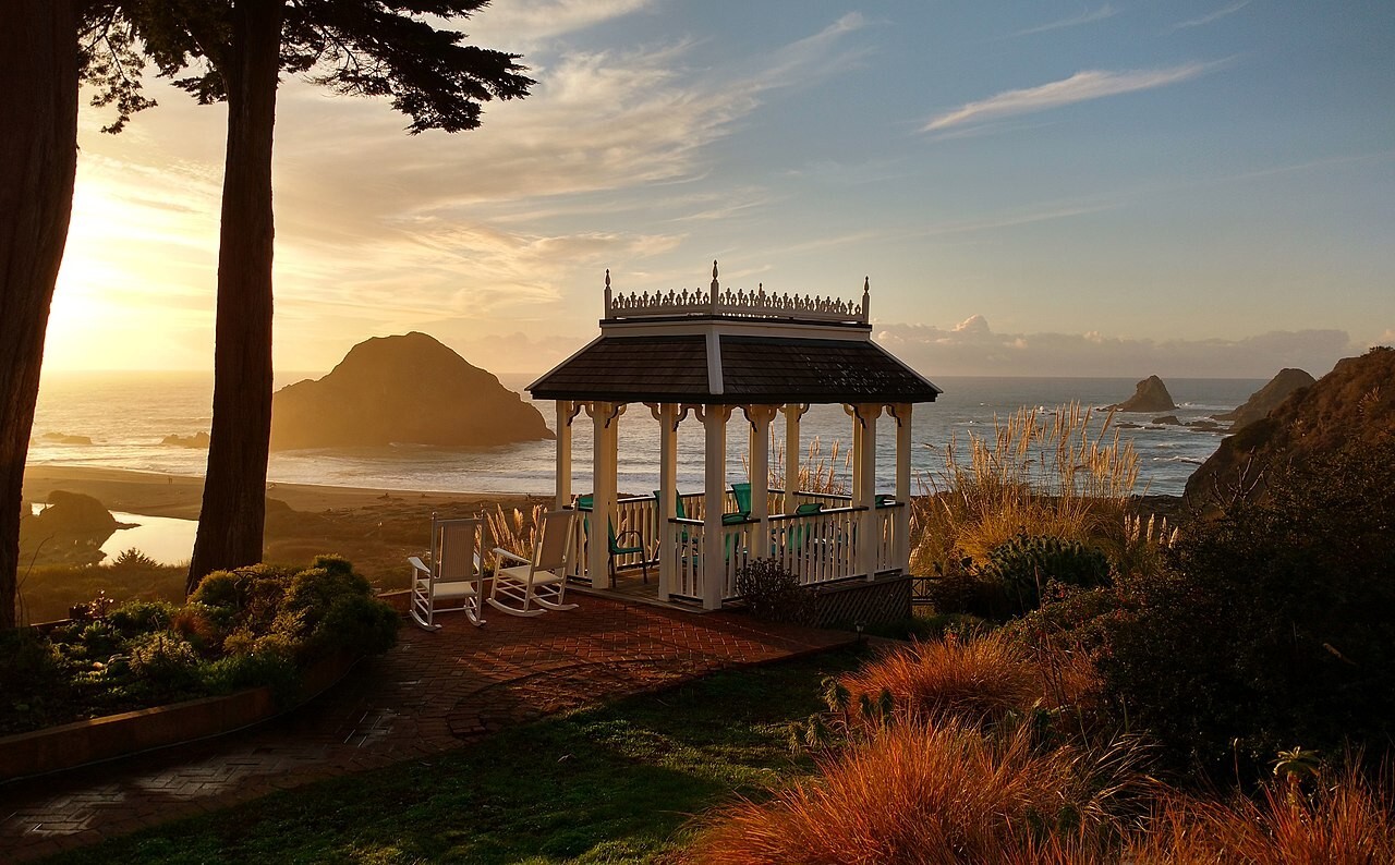 Gazebo overlooking ocean cliffs at sunset in Elk, California.