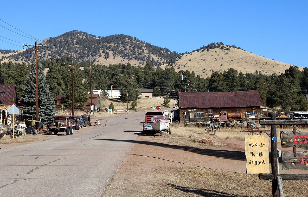 Rustic roadside town with mountain backdrop in Guffey, Colorado.