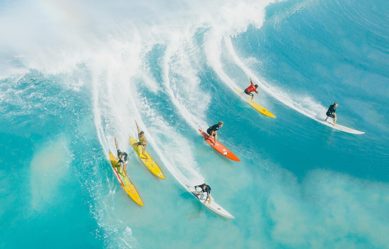 Surfers riding a big wave in Honolulu, Hawaii.