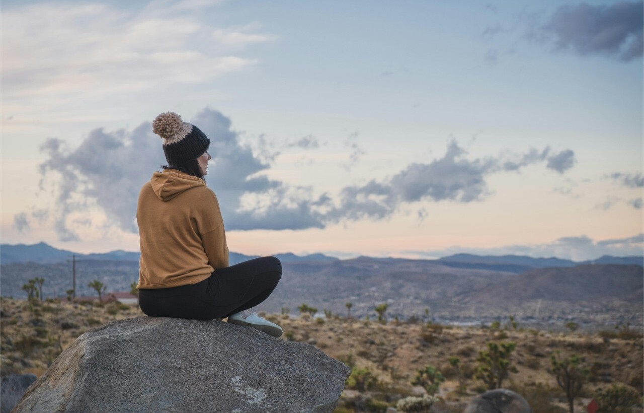 Woman sitting on rock overlooking desert at Keys View, Joshua Tree