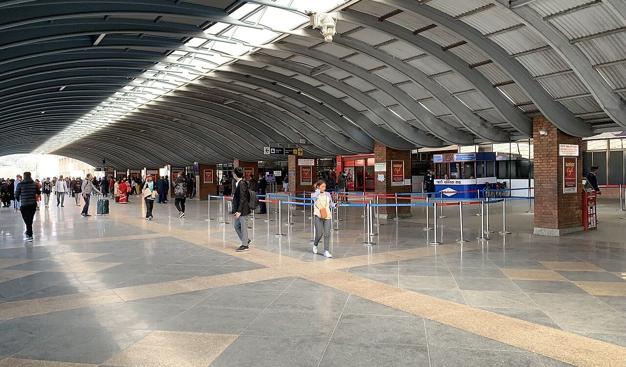 Kathmandu Tribhuvan Airport terminal with arched roof and travelers