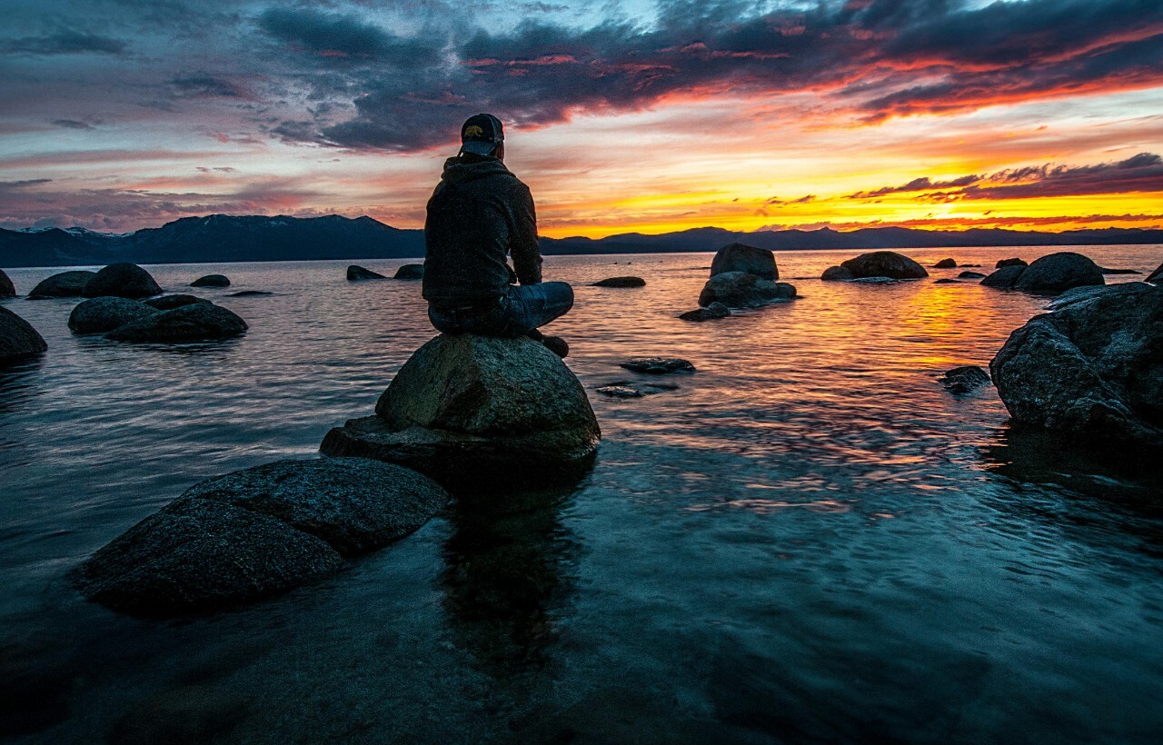 Person sitting on rock at sunset, Emerald Bay, Lake Tahoe