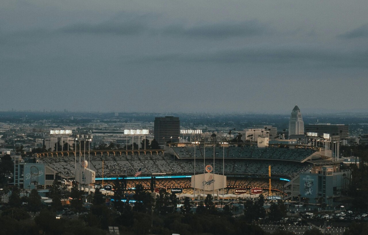 Dodger Stadium lit up in Los Angeles at dusk.