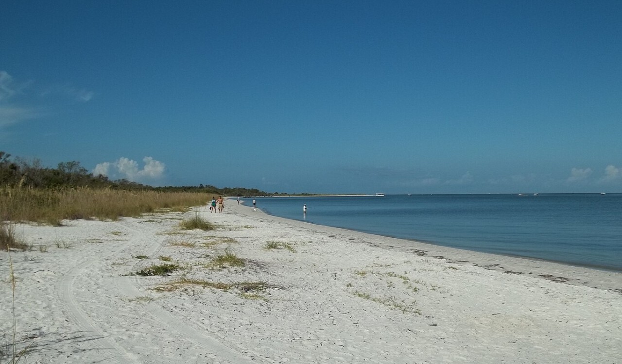 Quiet shoreline with walkers at Lovers Key State Park, Florida