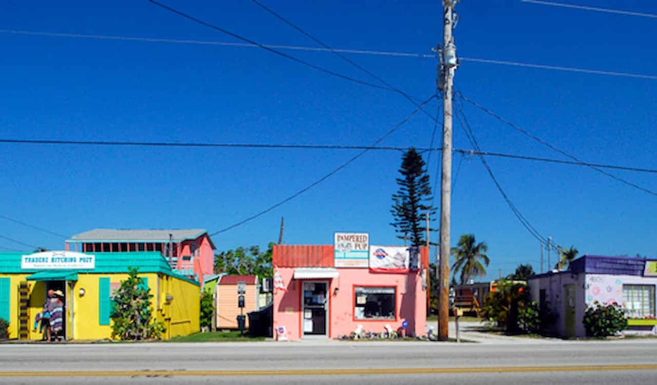Colorful roadside shops under clear blue sky in Matlacha, Florida.