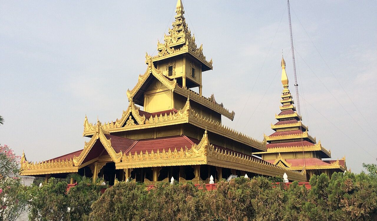 Golden temple in Myanmar with ornate, tiered roofs and rich cultural design