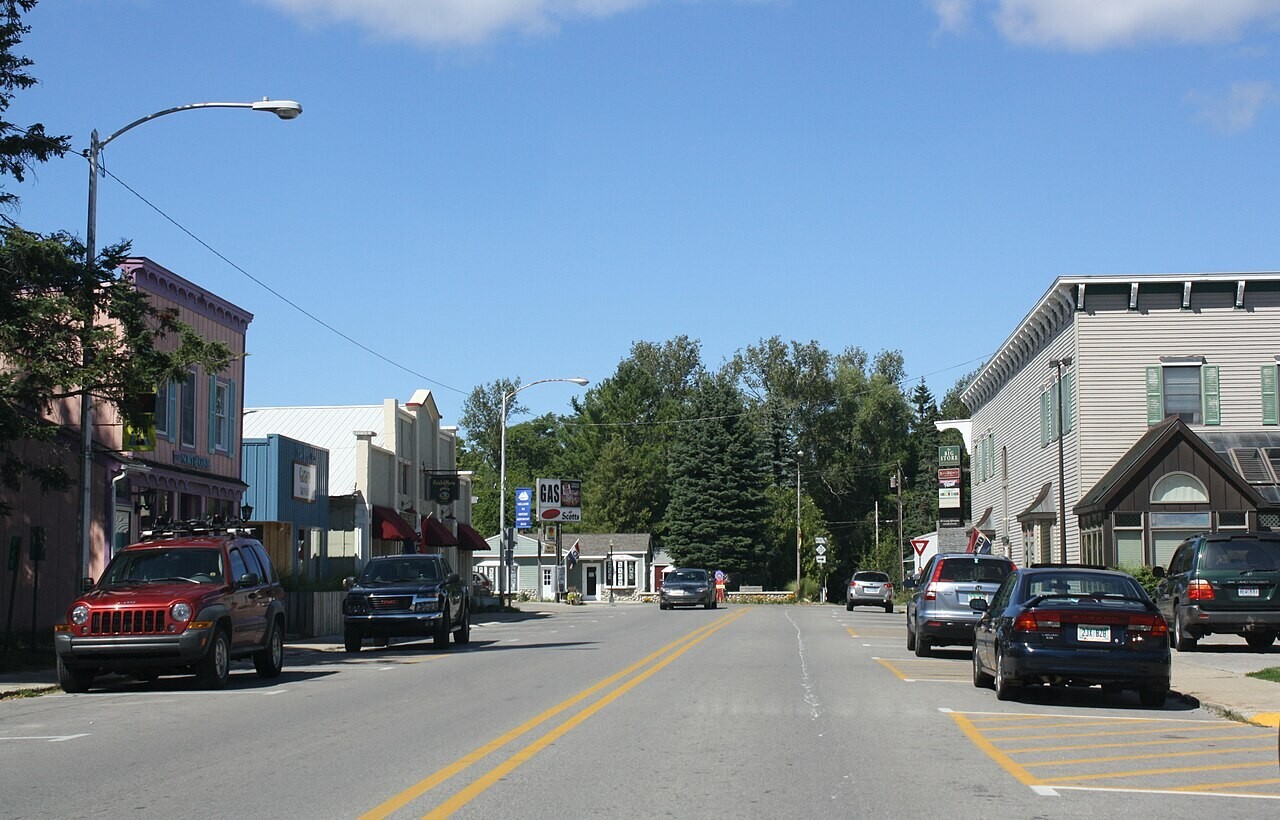 Quiet main street with shops and parked cars in Northport, Michigan.