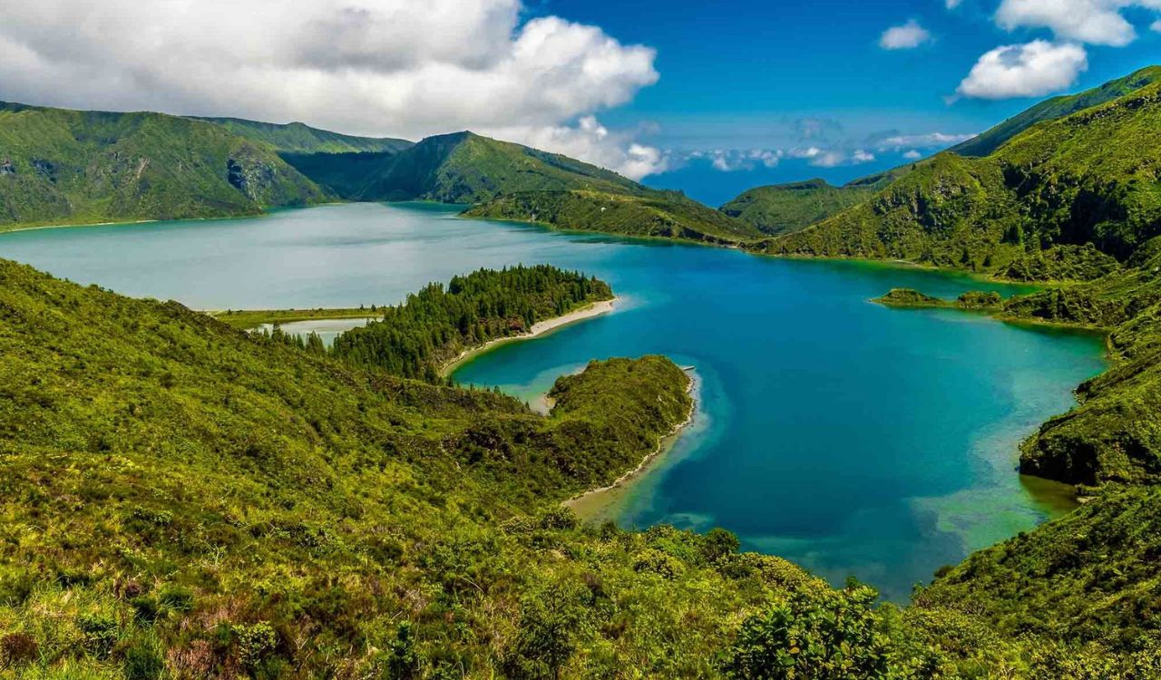 Emerald hills embrace serene turquoise lake