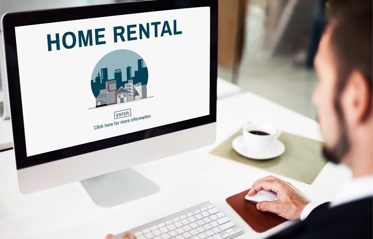 Man browsing a home rental website on desktop.