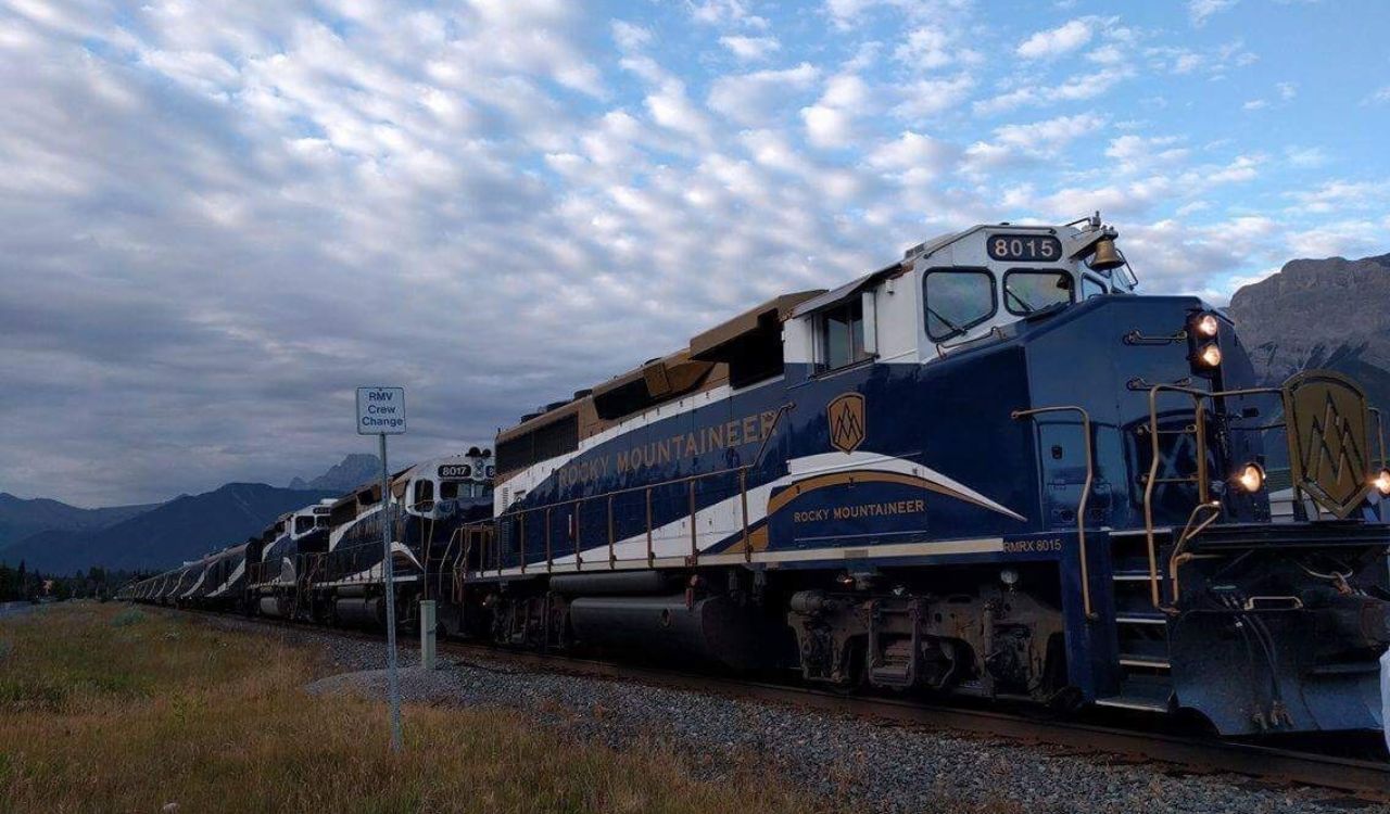 Rocky Mountaineer train under a dramatic sky with mountain views