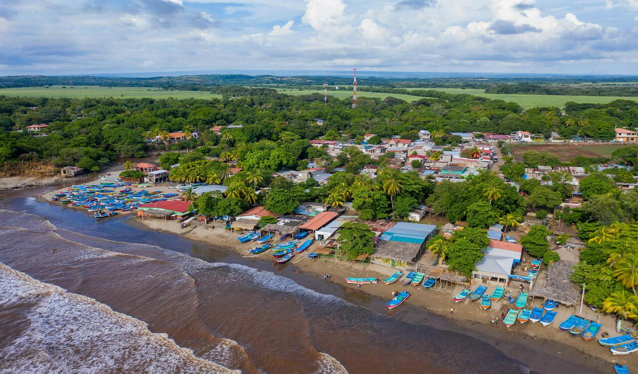 Aerial Photography of Houses and Wooden Boats on Beach