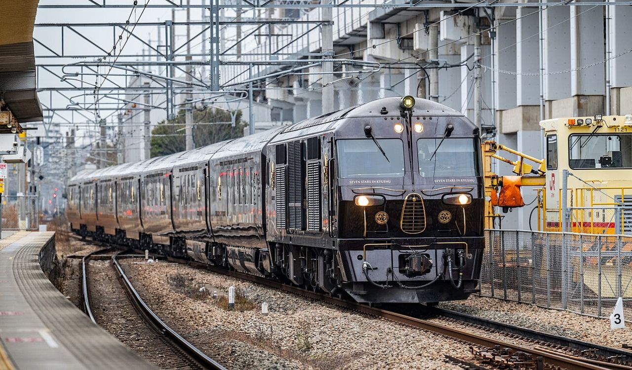 Luxurious black Seven Stars in Kyushu train arriving at a station in Japan