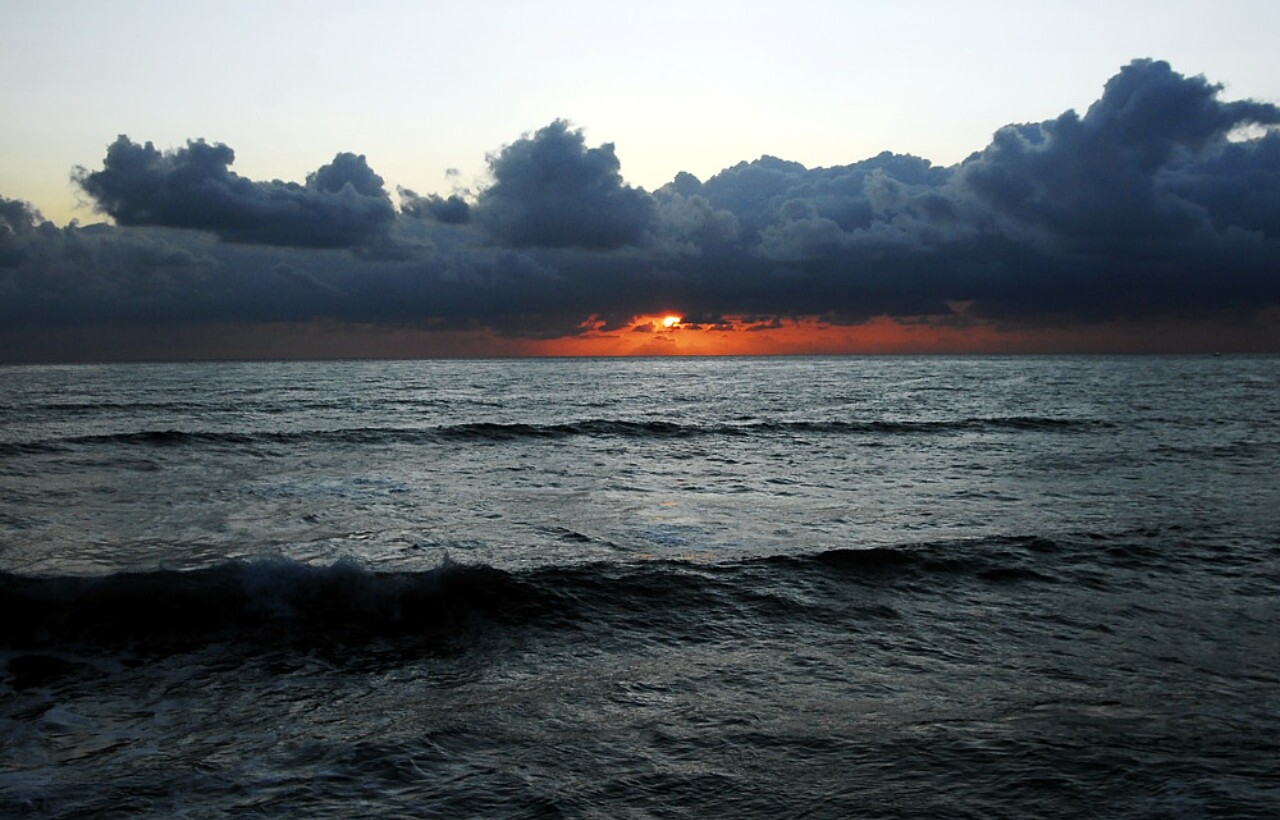Ocean sunset beneath dark clouds at Sunset Cliffs, San Diego