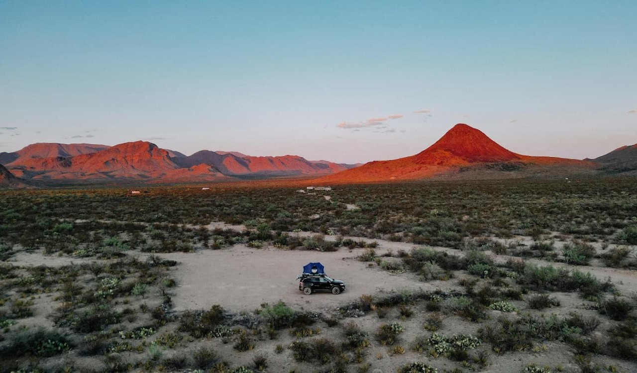 Desert campsite with red mountains at sunset in Terlingua, Texas.