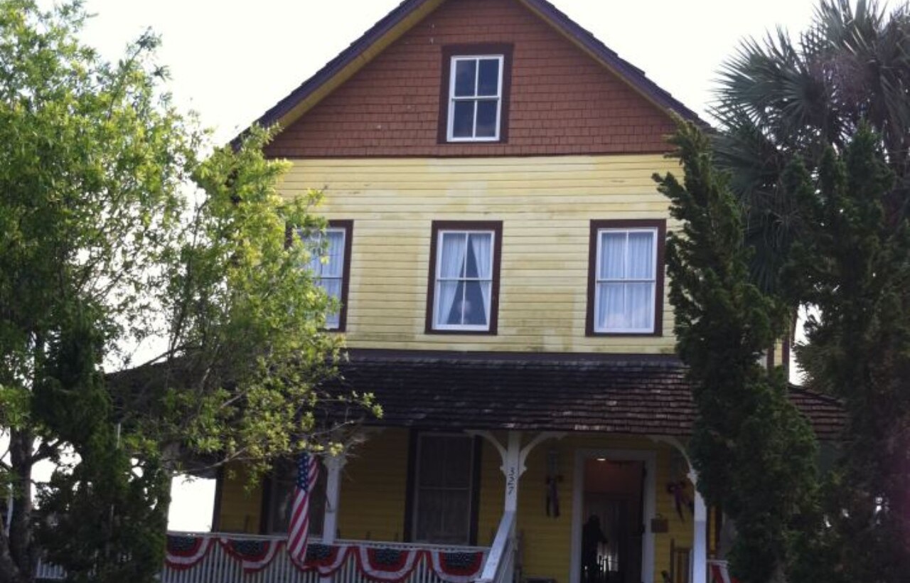 Yellow wooden exterior of The Riddle House in West Palm Beach, Florida.