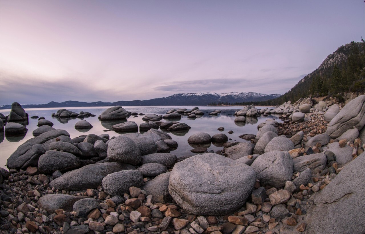 Smooth granite boulders by calm water at Lake Tahoe, United States