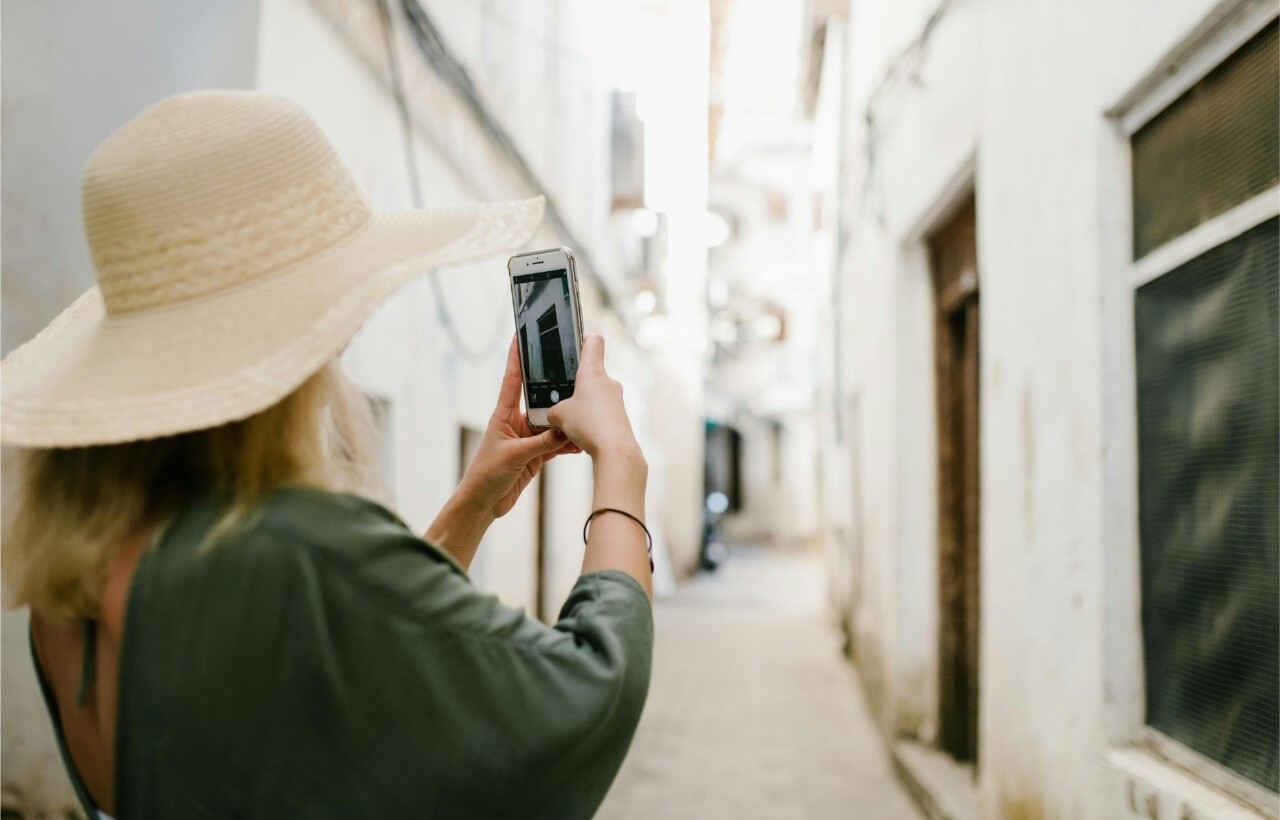 Woman photographing an alley.