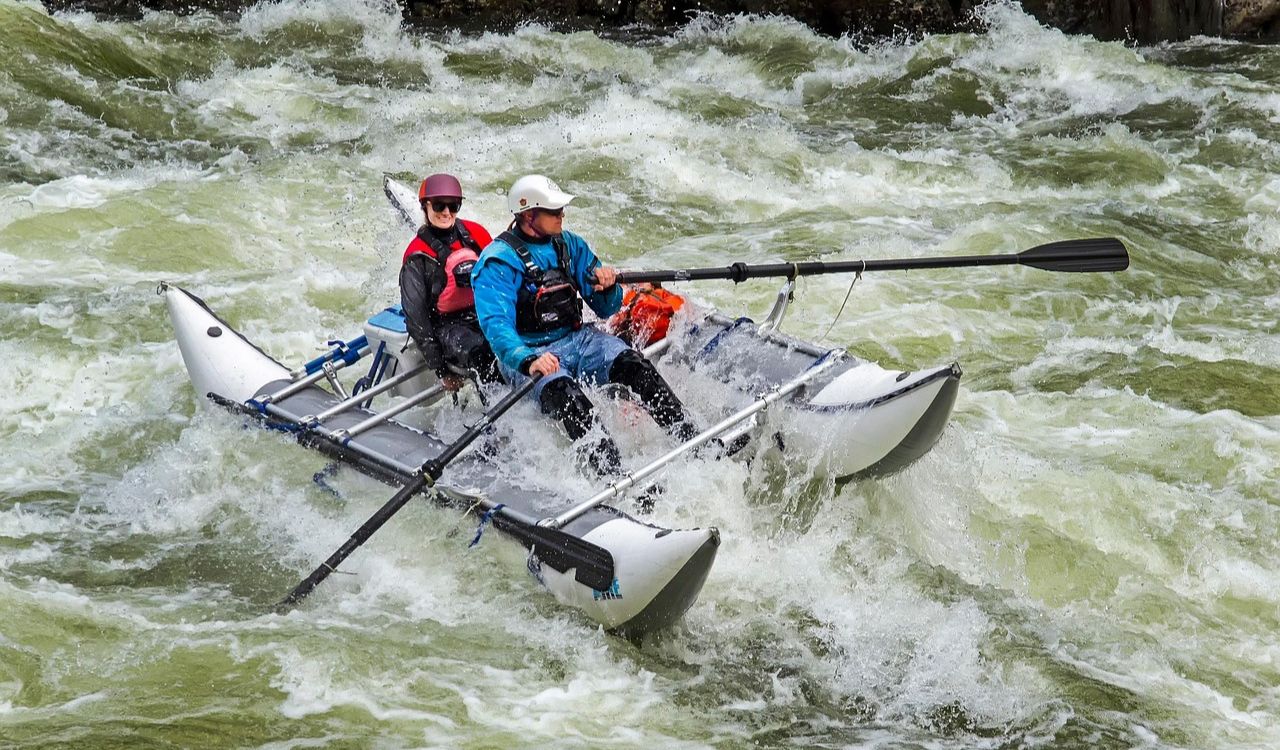 Adventurous couple rafting through wild rapids on the Zambezi River