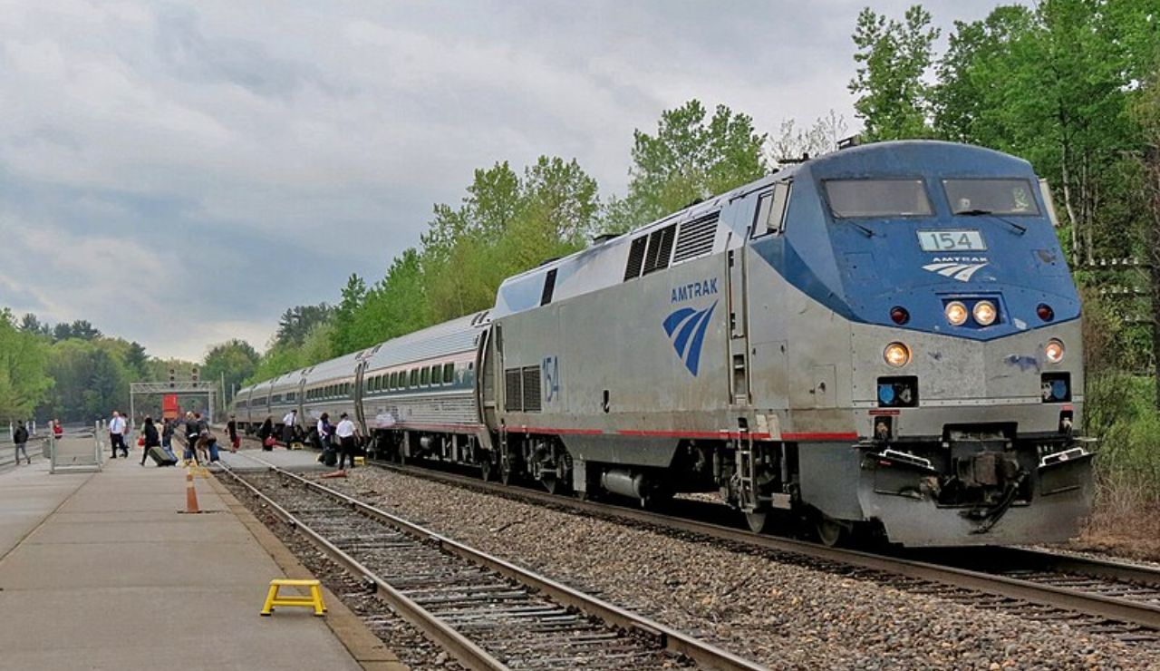 Amtrak Adirondack Train at a station platform surrounded by trees in New York.