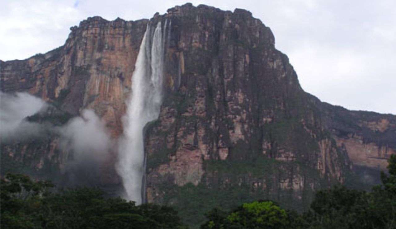 Angel Falls cascading from a towering cliff in Canaima National Park, Venezuela, surrounded by lush rainforest and misty clouds, world's tallest uninterrupted waterfall.