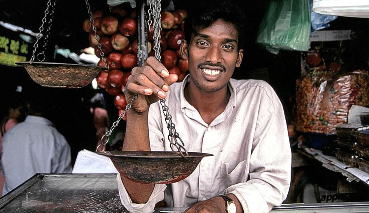 A tourist politely asking a question in a shop or market.