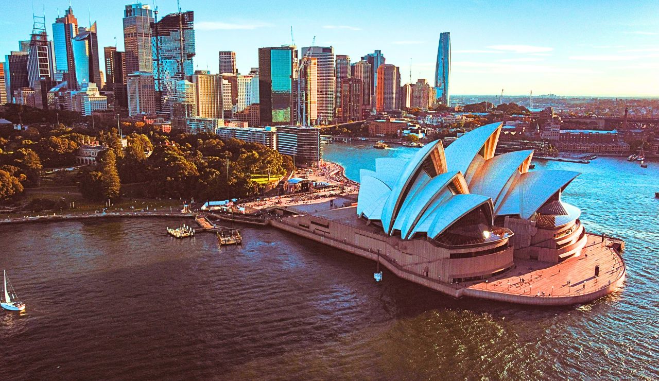 Sydney Opera House and harbor at sunset.