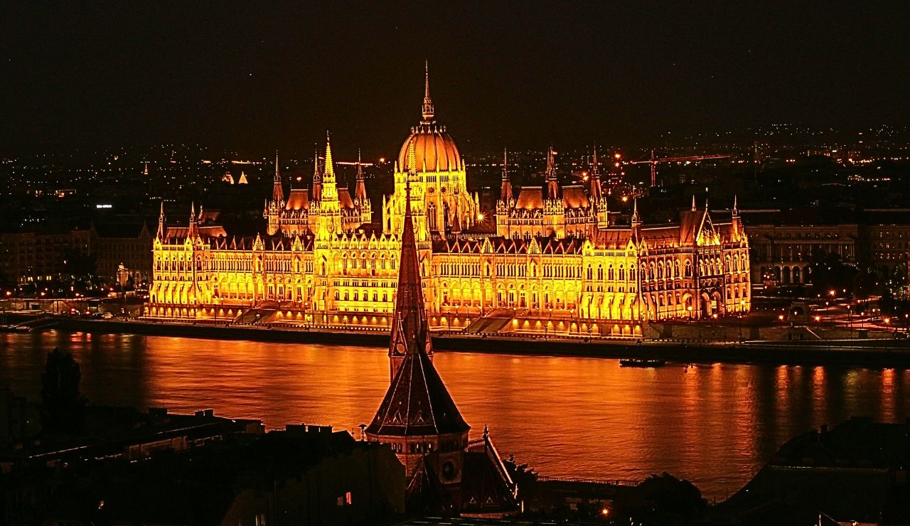 The Hungarian Parliament glowing at night beside the Danube River in Budapest. Slide Text