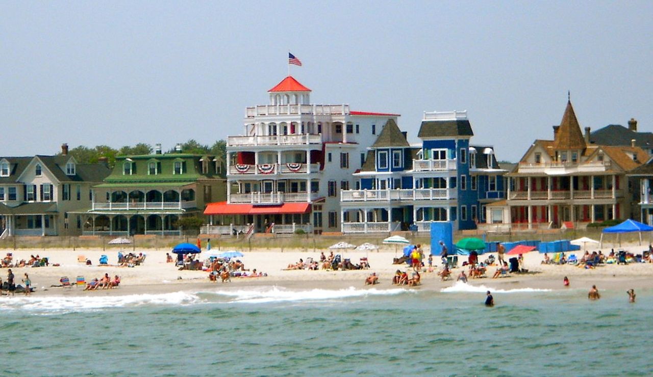 Colorful Victorian beachfront homes and sunbathers at Cape May, New Jersey.