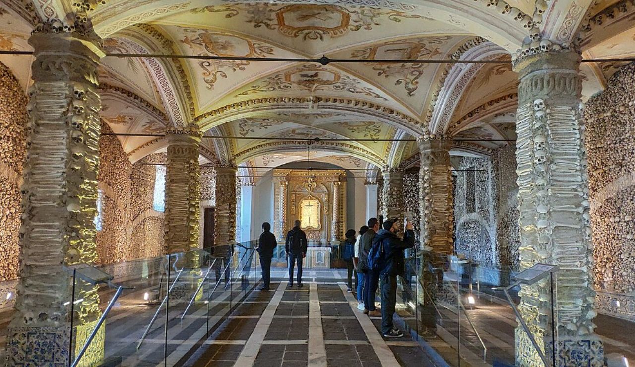 Visitors inside the Capela dos Ossos (Chapel of Bones) in Évora, Portugal.
